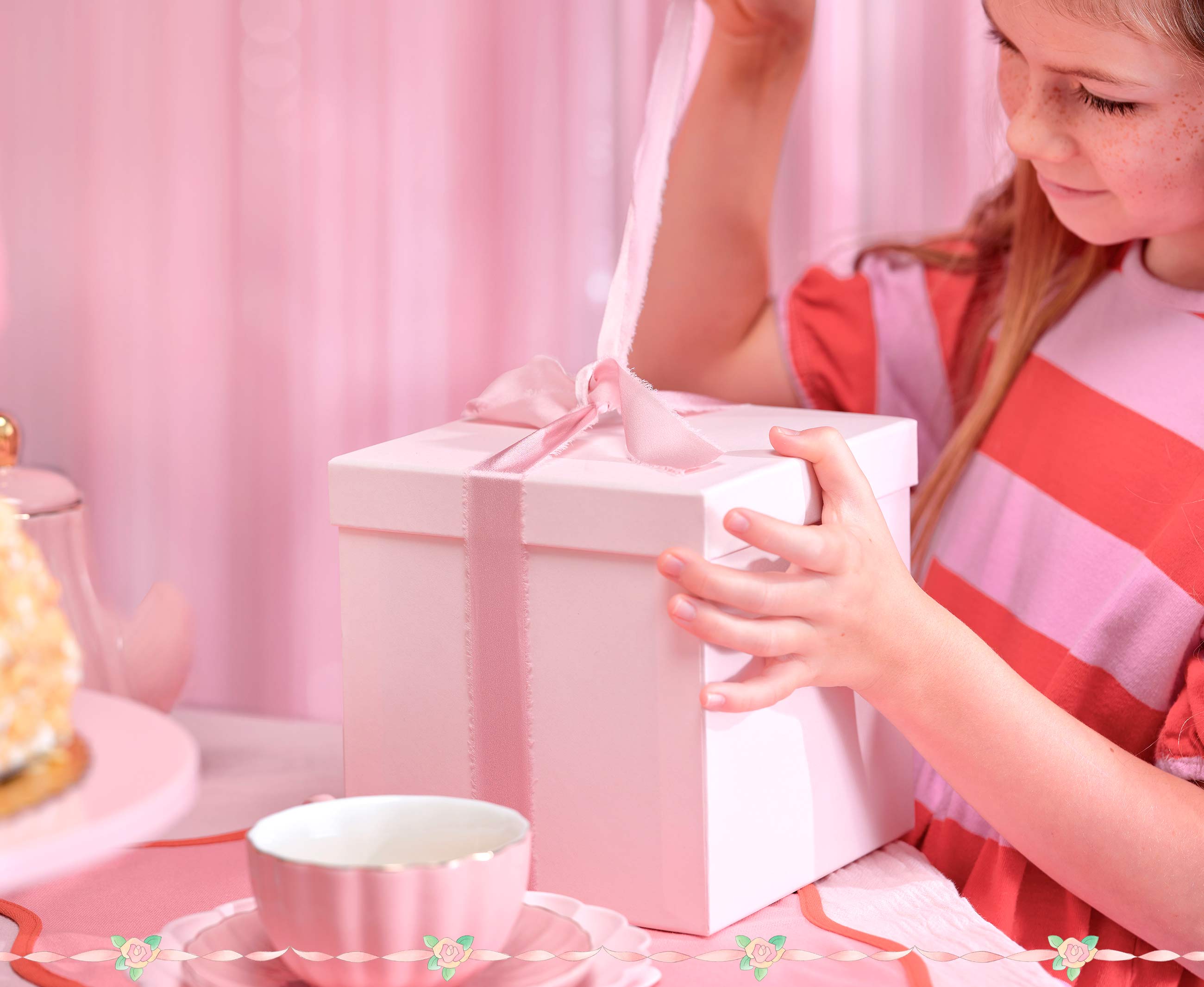 Child opening a gift box with a pink background